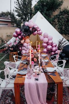 a table set up with balloons and candles