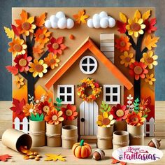 a paper house with fall leaves and pumpkins