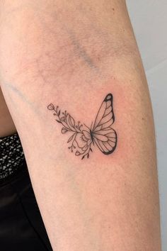 a black and white butterfly tattoo on the arm