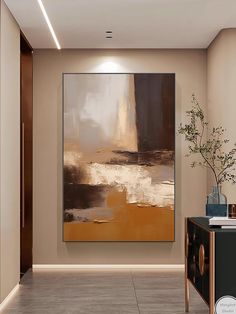 an abstract painting hangs on the wall next to a cabinet and vase with a plant in it