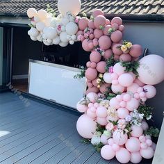 balloons and flowers decorate the outside of a house