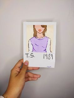 a hand holding up a drawing of a woman's face