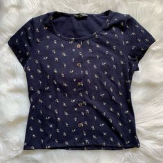 Adorable Tiny Floral Print Short Sleeve Tee! Cute Button Design (The Buttons Are Fake, Just For Looks) Dark Blue (Navy) Size Medium, But Would Best Fit A Small In My Opinion Nwot Not Brandy Melville - Tagged For Exposure Bundle Items For A Killer Discount Trendy Spring T-shirt With Buttons, Blue Buttoned T-shirt For Summer, Blue Button-up T-shirt For Summer, Blue Crew Neck T-shirt With Buttons, Casual Blue T-shirt With Buttons, Blue T-shirt With Button Closure And Crew Neck, Blue Crew Neck Blouse With Buttons, Blue Crew Neck Shirt With Button Closure, Blue Floral Print Button-up Top