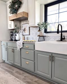 a kitchen with gray cabinets and white counter tops