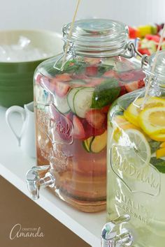 two mason jars filled with different types of fruit and veggies on a counter