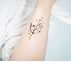 an anchor tattoo with flowers on the arm