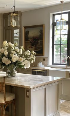 a vase with white flowers sitting on top of a kitchen island