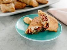 two plates with pastries on them next to some other food items in the background