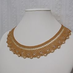 Wide Gold Netted Collar. This necklace was made with a netted weave using the smallest beads made, they are about 1mm each.  The color is matte gold.  The tiny beads make this collar very soft and fluid, like a lame fabric.  It is about 1 1/8 inch wide all around.  It has an extra length of 14kt gold filled chain to allow for adjustments  between 16 and 18 1/2 inches. There is a large, easy to use Hamilton gold lobster clasp closure.   Shipping is via first class mail, USPS. We ship in 1 - 3 business days, most times within 24 hours. Tracking is included. Pattern is by Poe. Gold Choker With Round Beaded Chain, Yellow Gold Beaded Necklace For Wedding, Wedding Yellow Gold Beaded Necklaces, Elegant Gold Necklaces With Spacer Beads, Elegant Gold Beaded Necklace With Spacer Beads, Elegant Gold Beads Choker Necklace, Elegant Gold Beaded Choker Necklace, Adjustable Gold Beaded Necklaces With Bead Caps, Adjustable Gold Chain Necklace With Gold Beads