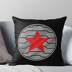 a red star in the center of a black and grey circle throw pillow on a couch