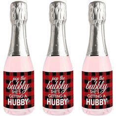 three bottles of pink liquid with red and black plaid designs on them, one is empty