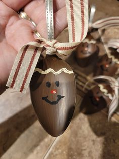 a hand holding an ornament shaped like a nut with a face on it