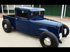 an old blue truck parked in front of a building