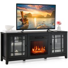 a flat screen tv sitting on top of a black entertainment center next to a fire place