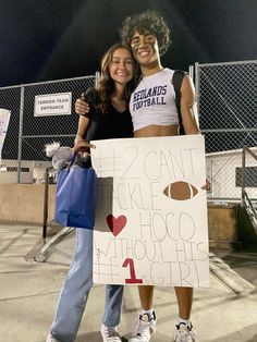 two girls are posing with a sign that says football