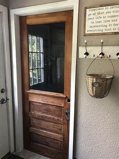 a wooden door with a basket hanging on the wall next to it's glass front door