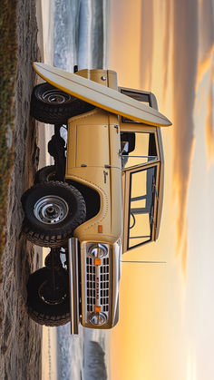 A vintage Ford Bronco parked on a beach with a surfboard leaning against the side. The Bronco is tan in color and has large off-road tires. 70s Ford Bronco, Vintage Ford Bronco Yellow, Ford Bronco Old Classic Trucks, Vintage Ford Bronco Convertible, Mini Trucks 4x4, Ford Bronco 1966-1977