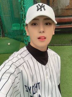 a young man in a baseball uniform poses for a photo