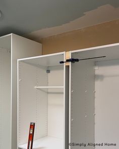 an empty closet is shown with the door open and tools on the shelf next to it