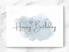 a card with the words happy birthday written in black ink on a white marble background