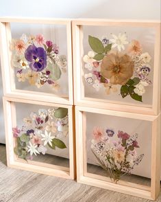 four wooden frames with pressed flowers in them