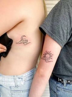 two people with tattoos on their stomachs, one has a sun and the other has a wave