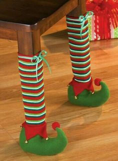 two legs with christmas stockings tied to them, standing on top of a wooden table