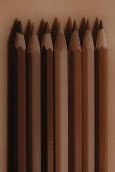 several pencils lined up in a row on a wall