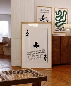 a room with wooden floors and pictures on the wall, including two framed playing cards