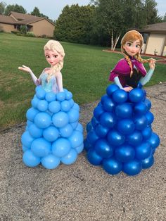 two frozen princesses standing next to each other in front of blue balloons on the ground