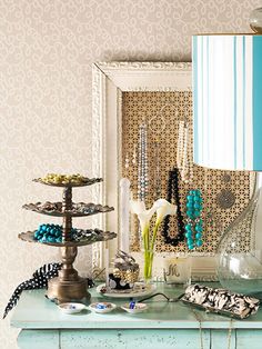 a table topped with lots of jewelry and a lamp