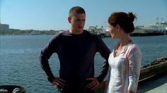 a man standing next to a woman on top of a pier