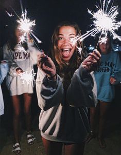 the girl is holding sparklers in her hands