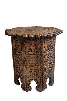 an intricately carved wooden table with carvings on the top and bottom, against a white background