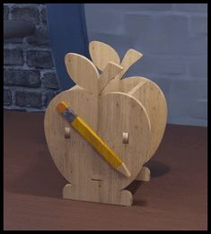 a wooden apple shaped pencil holder with a yellow pencil sticking out of it's side