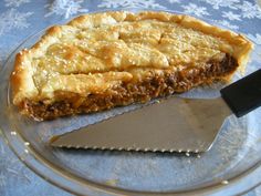 a piece of pie sitting on top of a glass plate with a knife next to it