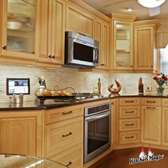 a kitchen with wooden cabinets and stainless steel appliances, including microwave, dishwasher