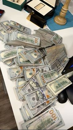 a pile of money sitting on top of a table next to a computer mouse and keyboard