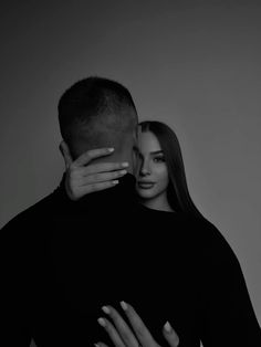 a man and woman embracing each other in black and white