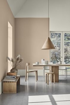 a dining room table and chairs in front of large windows with lots of natural light