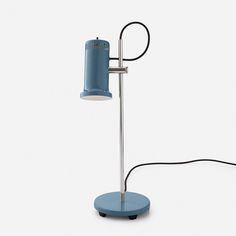 a blue table lamp sitting on top of a white floor next to a black cord