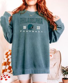 Capture the nostalgia of Philadelphia football with this vintage-style Comfort Colors sweatshirt! Inspired by classic retro designs, this crewneck is perfect for die-hard Eagles fans looking to show off their team spirit in a stylish and cozy way. Made from premium Comfort Colors fabric, this sweatshirt offers a relaxed, lived-in feel that's perfect for game days, casual outings, or lounging at home. Featuring a bold, retro Philadelphia football design, it's a must-have addition to your collecti Retro Fan Gear Sweatshirt For Sports Season, Retro Crew Neck Sweatshirt For Fan Merchandise, Vintage Sweatshirt For Sports Season Fan Merchandise, Philadelphia Eagles Sweater, Vintage Philadelphia Eagles, Vintage Eagles Sweatshirt, Vintage Philadelphia Eagles Sweatshirt, Comfort Colors Sweatshirt, Football Design