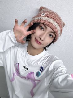 a young woman wearing a hat making the peace sign