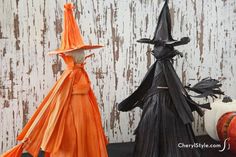 two halloween decorations are sitting on a table next to each other, one is wearing a witch hat and the other has a pumpkin