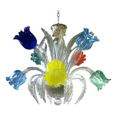 a glass chandelier hanging from a chain with five different colored birds on it