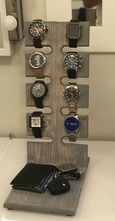 there are many watches on the shelf in this bathroom mirror case, which is attached to a towel rack