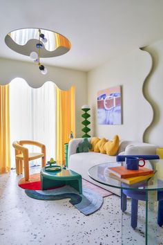 a living room filled with furniture and colorful accessories on top of a white floor covered in lots of windows