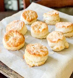 some biscuits are sitting on a piece of wax paper and ready to be baked in the oven