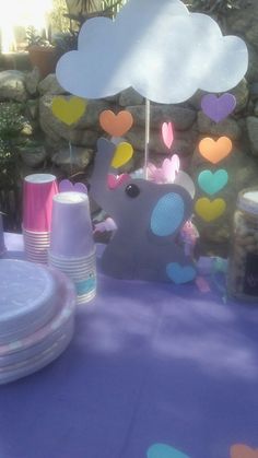 a table topped with plates and cups under a cloud