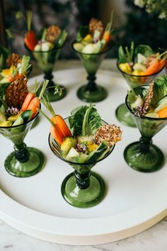 there are many small bowls with food in them on the table, including carrots and celery